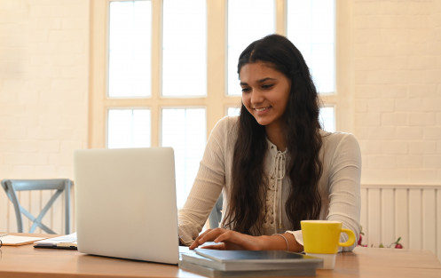 university-student-is-learning-lessons-online-while-sitting-wooden-working-desk_35674-2660